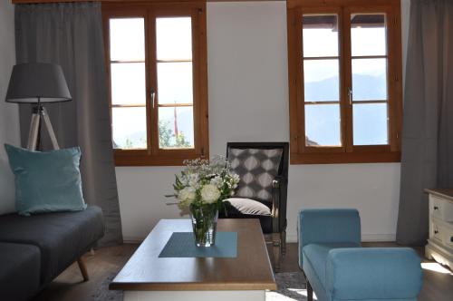 a living room with a vase of flowers on a coffee table at App. Seeblick Top of Interlaken in Beatenberg