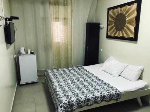 a bed room with a white bedspread and a white wall at Ashel Hotel in Beer Sheva