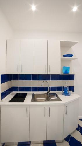 a kitchen with white cabinets and a sink at Marilisa Holidays in Maiori