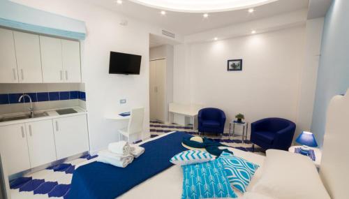 a room with a bed and two blue chairs at Marilisa Holidays in Maiori