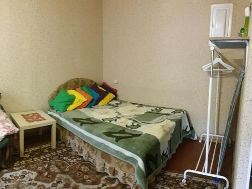クルガンにあるMaxim Gorky Apartmentsの小さなベッドルーム(緑の毛布付きのベッド付)