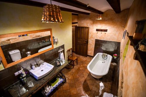 a bathroom with a sink and a mirror and a toilet at La Mora Cantana in Castrojeriz
