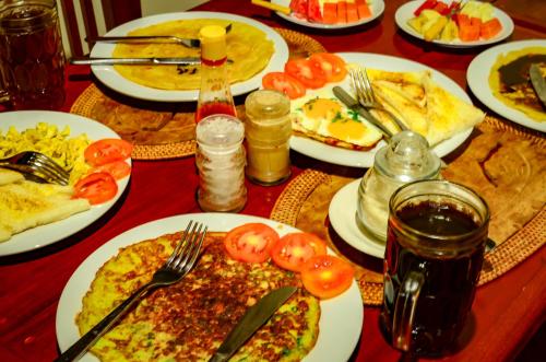 una mesa llena de platos de comida con tomates. en Mapa Lake View Bungalow, en Kintamani