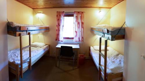 a room with two bunk beds and a desk at Halens Camping och Stugby in Olofström