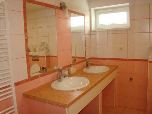 a bathroom with two sinks and a mirror at Ubytovanie Kubik 473 in Liptovský Mikuláš