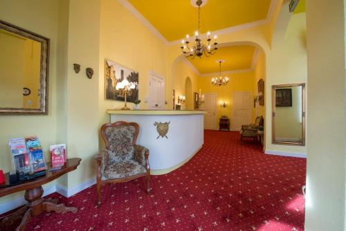 a living room with a chair and red carpet at Hotel Knöpel in Wismar