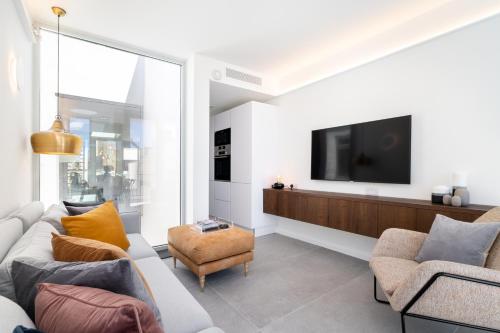a living room with a couch and a tv at Amazing Art Deco Villa 150m to sea with Daily Housekeeping in Sliema
