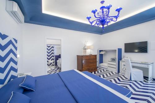 a blue and white bedroom with a bed and a tv at Hotel Villa Maria Pia in Praiano