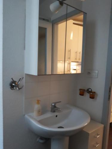 W łazience znajduje się umywalka i lustro. w obiekcie Le Quai 2 w Strasburgu