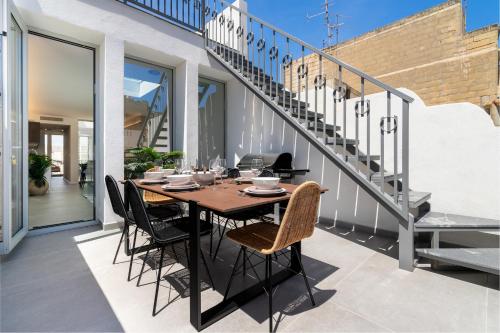 a dining table on the balcony of a house at Amazing Art Deco Villa 150m to sea with Daily Housekeeping in Sliema