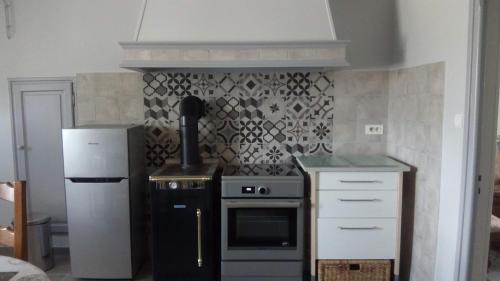 een keuken met een fornuis en een koelkast bij Maison de Romagers in Aumont-Aubrac
