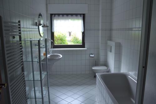 La salle de bains est pourvue d'une baignoire, de toilettes et d'un lavabo. dans l'établissement Ferienhaus „Dorsch“, à Ostseebad Koserow