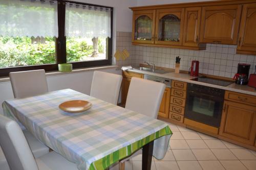 cocina con mesa, sillas, mesa y mantel en la parte superior en Ferienhaus „Dorsch“ en Ostseebad Koserow