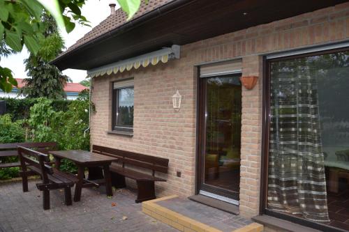 een patio met een tafel en banken naast een gebouw bij Ferienhaus „Dorsch“ in Ostseebad Koserow
