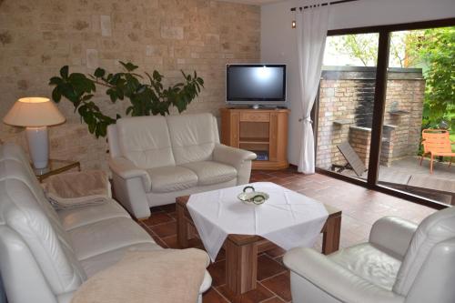 d'un salon avec un mobilier blanc et une télévision. dans l'établissement Ferienhaus „Dorsch“, à Ostseebad Koserow