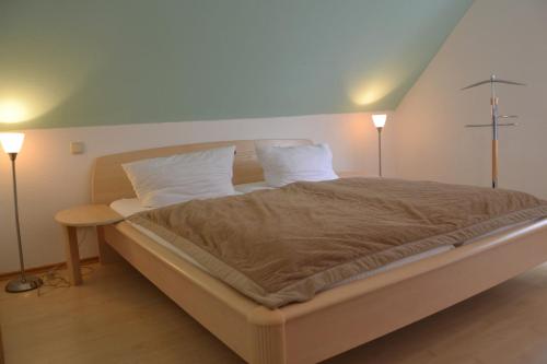 a bedroom with a large bed with two lamps at Ferienhaus „Dorsch“ in Ostseebad Koserow