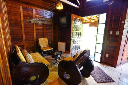 a living room with a couch and a chair at Pousada Recanto das Aves in Iguape