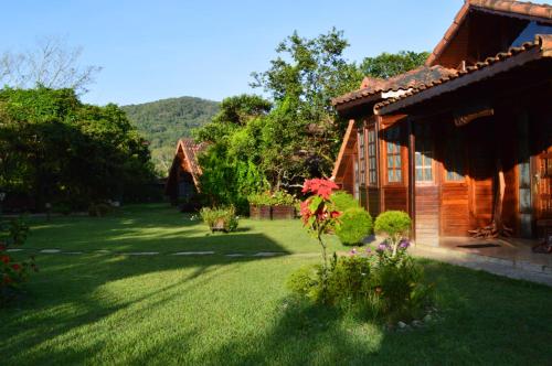 a yard of a house with green grass at Pousada Recanto das Aves in Iguape