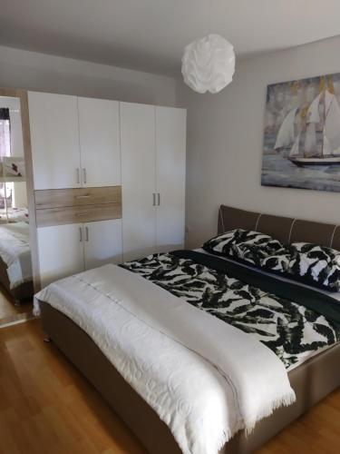 a bedroom with a bed with a black and white blanket at Apartman Manuela in Matulji