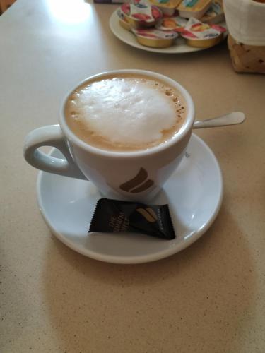 a cup of coffee on a plate on a table at Hotel Pazo de Berbetoros in Portomarin