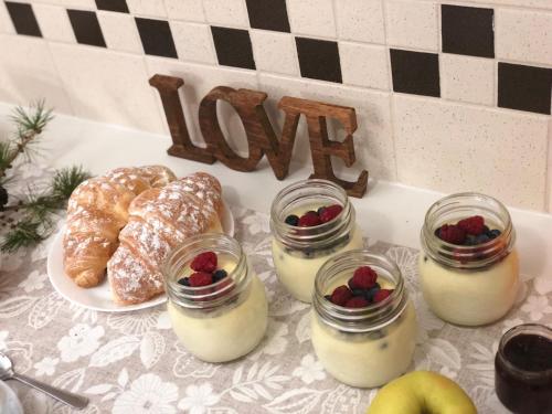 a table topped with pastries and berries in jars at DAD HOME in Cles