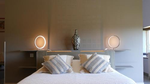 a bedroom with a bed with pillows and two mirrors at domaine du vernay in Mazille