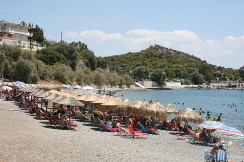 a group of people sitting on a beach with umbrellas at Studio in Selínia