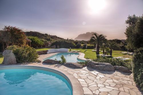 una piscina con rocas en un patio en Hotel Ollastu, en Costa Corallina