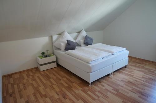 un letto bianco con cuscini sopra di Die schönste Unterkunft im Odenwald a Wald-Michelbach