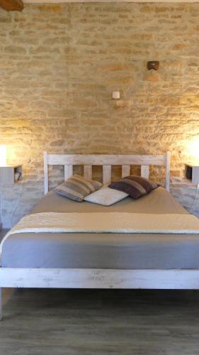 a bed in a room with a brick wall at domaine du vernay in Mazille