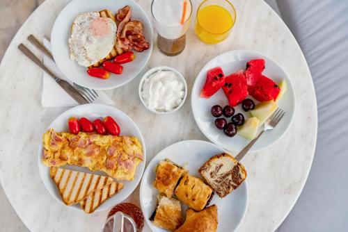 a table with plates of breakfast food on it at Ethrion in Ermoupoli