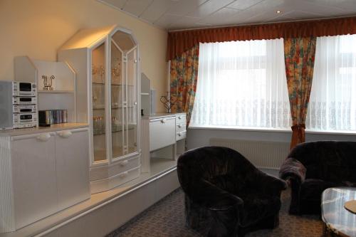 a living room with two chairs and a large window at Ferienwohnung Oleanderhof in Zossen