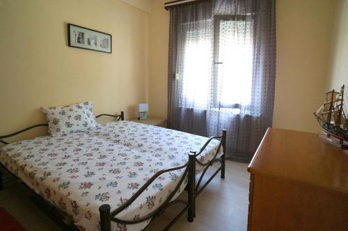 una camera con letto, cassettiera e finestra di Katerina's apartment a Kavala