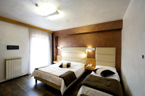 a hotel room with two beds and a window at Sport Village Hotel & Spa in Castel di Sangro