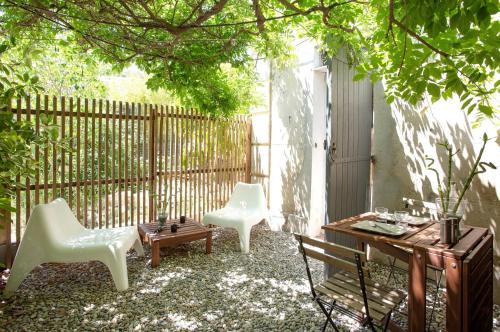トゥーロンにあるGregBnb-com - Studio CLIMATISÉ - Terrasse & parking privéのパティオ(白い椅子2脚、テーブル、フェンス付)