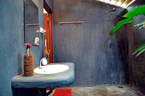 a bathroom with a sink and a blue wall at Chez Podi Surf Stay in Mirissa