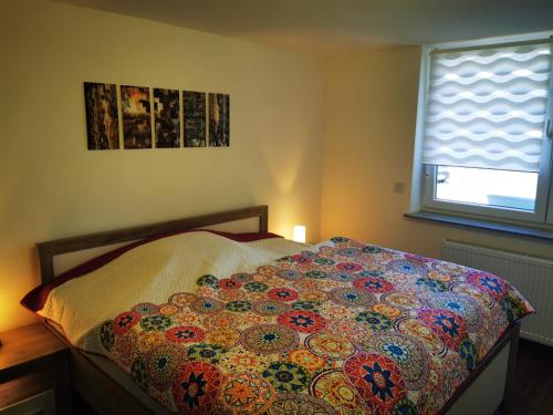 a bedroom with a bed with a colorful blanket on it at Ferienhaus Oebel in Brüggen in Brüggen