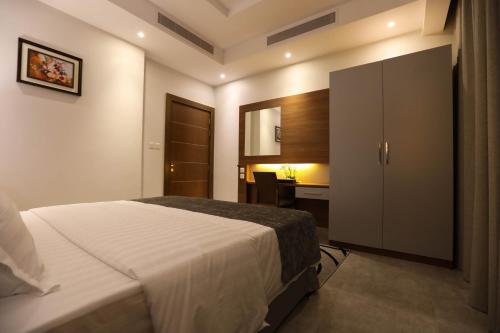 a bedroom with a large bed and a desk at Diamond Tower Hotel in Jeddah