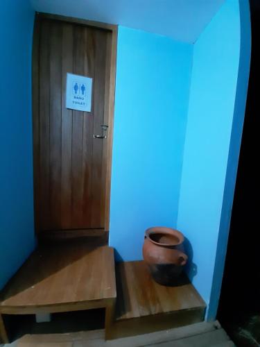 a room with a wooden door and a pot on the stairs at Quechua lodge Titicaca in Puno