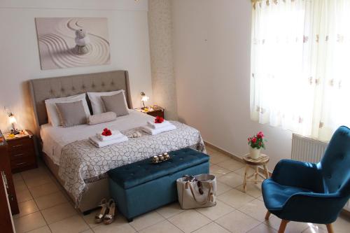 a bedroom with a bed and a blue chair at Amazing Beachfront Apartment in Hersonissos in Hersonissos