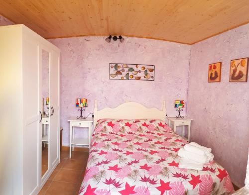 1 dormitorio con 1 cama con pared de color rosa en Casa Eloísa, en Alarcón