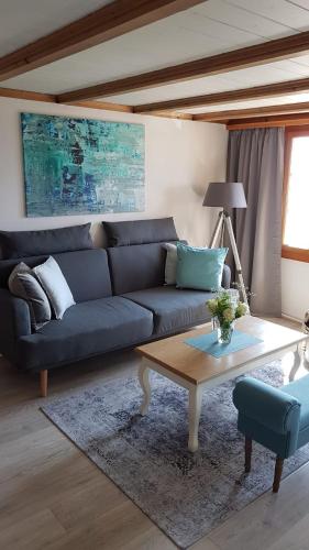a living room with a blue couch and a coffee table at App. Seeblick Top of Interlaken in Beatenberg