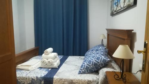 a bedroom with a bed with a blue curtain at VFT El Castillo in La Iruela