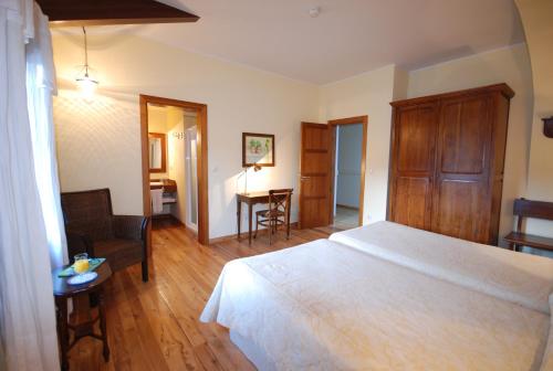 a bedroom with a bed and a chair and a table at Hotel Del Verde Al Amarillo in Peñasrubias de Pirón