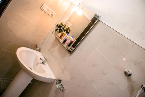 W łazience znajduje się biała umywalka i lustro. w obiekcie BIVORA Villa w Negombo