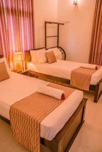 a hotel room with two beds in a room at BIVORA Villa in Negombo