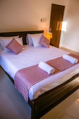 a large bed with two pillows on top of it at BIVORA Villa in Negombo