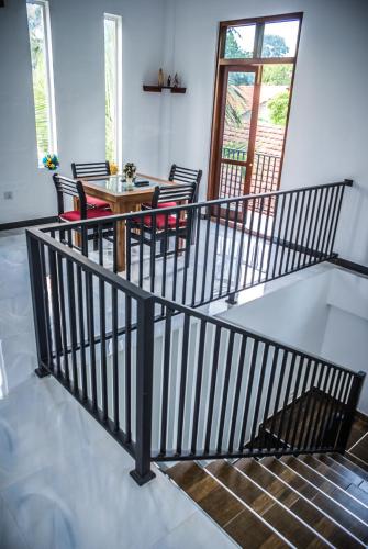a room with a staircase with a table and chairs at BIVORA Villa in Negombo