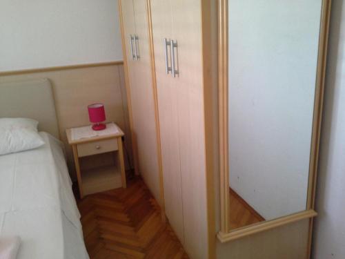 - une petite chambre avec un lit et un miroir dans l'établissement ROOMS LUCE 2 & Supetar, à Supetar