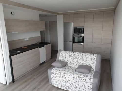 un salon avec un canapé et une cuisine dans l'établissement Le P'tit Benèze, à Royan